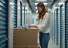 Découvrez les avantages d’une solution de stockage : Homebox, pourquoi y recourir ? Jeune femme rangeant des vêtements dans un box de stockage
